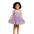 Young girl wearing a purple floral dress against a beige background