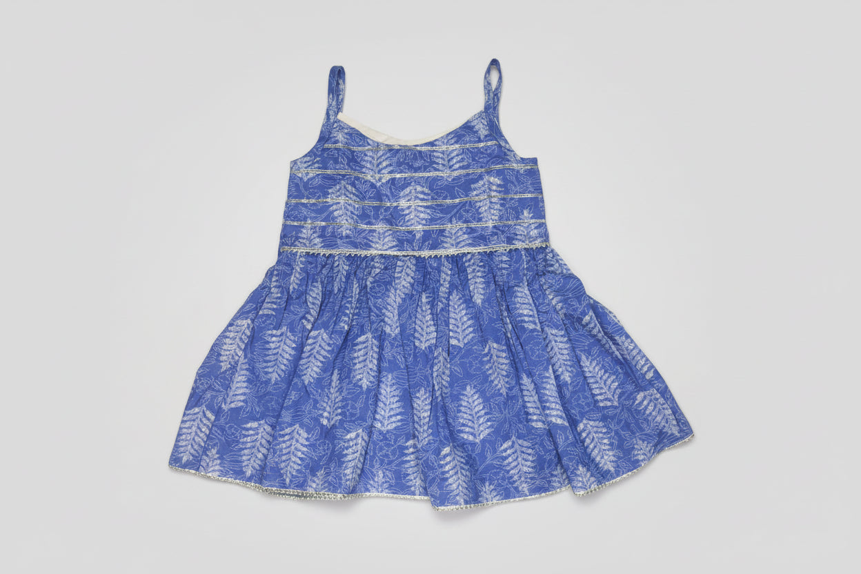 Blue dress with white leaf pattern on a textured surface