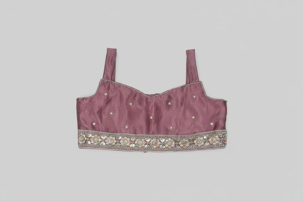 Maroon embroidered top on a textured gray background