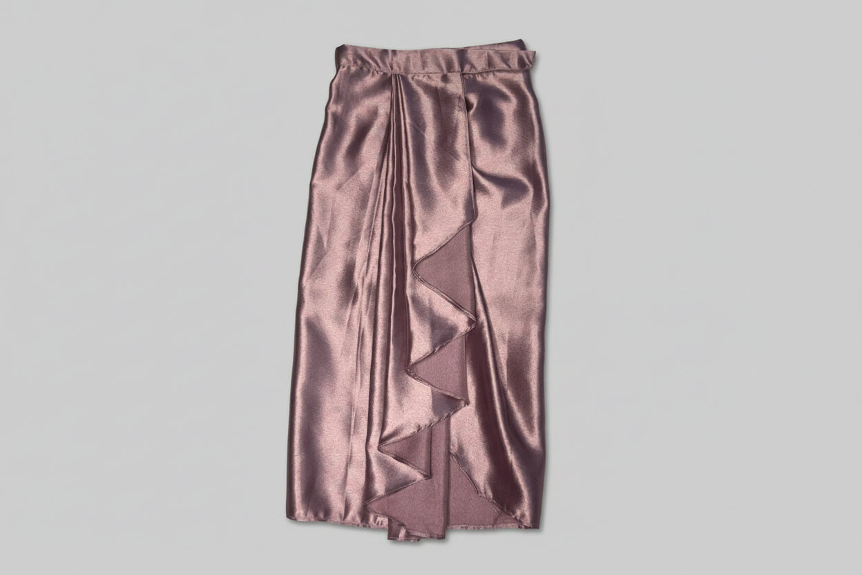 Satin skirt with ruffled detailing on a textured surface
