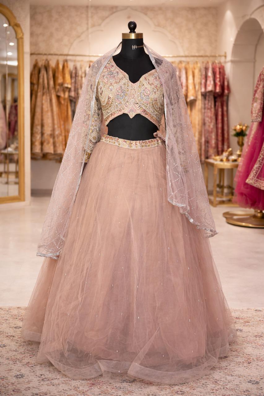 Traditional outfit with a beige dupatta and black blouse on a mannequin in a store setting.