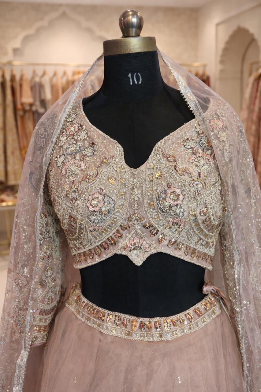 Elegant embroidered blouse with a sheer dupatta on a mannequin in a store setting.