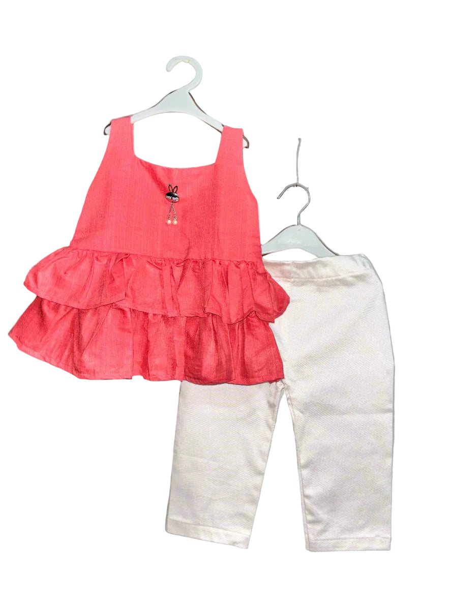 Red ruffled top and white pants on hangers against a gray background