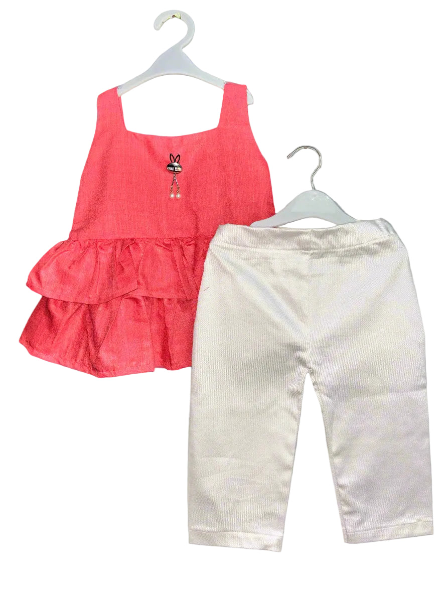 Red tiered top and white pants on hangers against a gray background