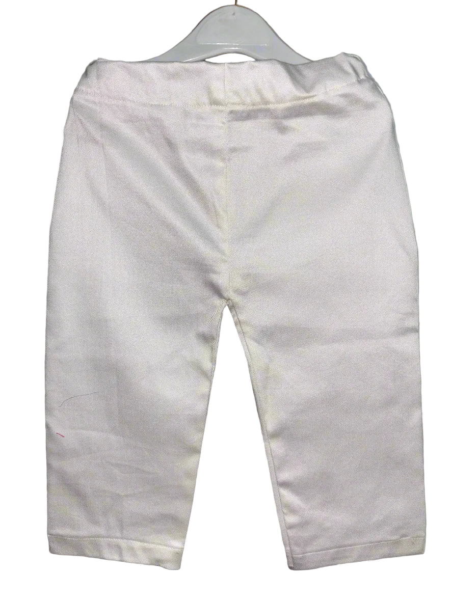White pants on a hanger against a gray background