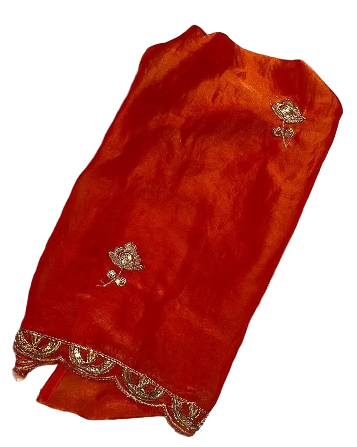 Red fabric with floral embroidery on a textured white background